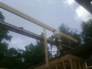 Carpenter setting a ridge beam over a new addition frame — Ice Dam Removal by Roofing Brothers in Laguna Beach