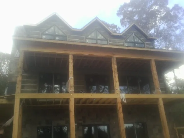 Dormers and porch framing on a large log home under construction — Roof Coating work by our crew in Laguna Beach